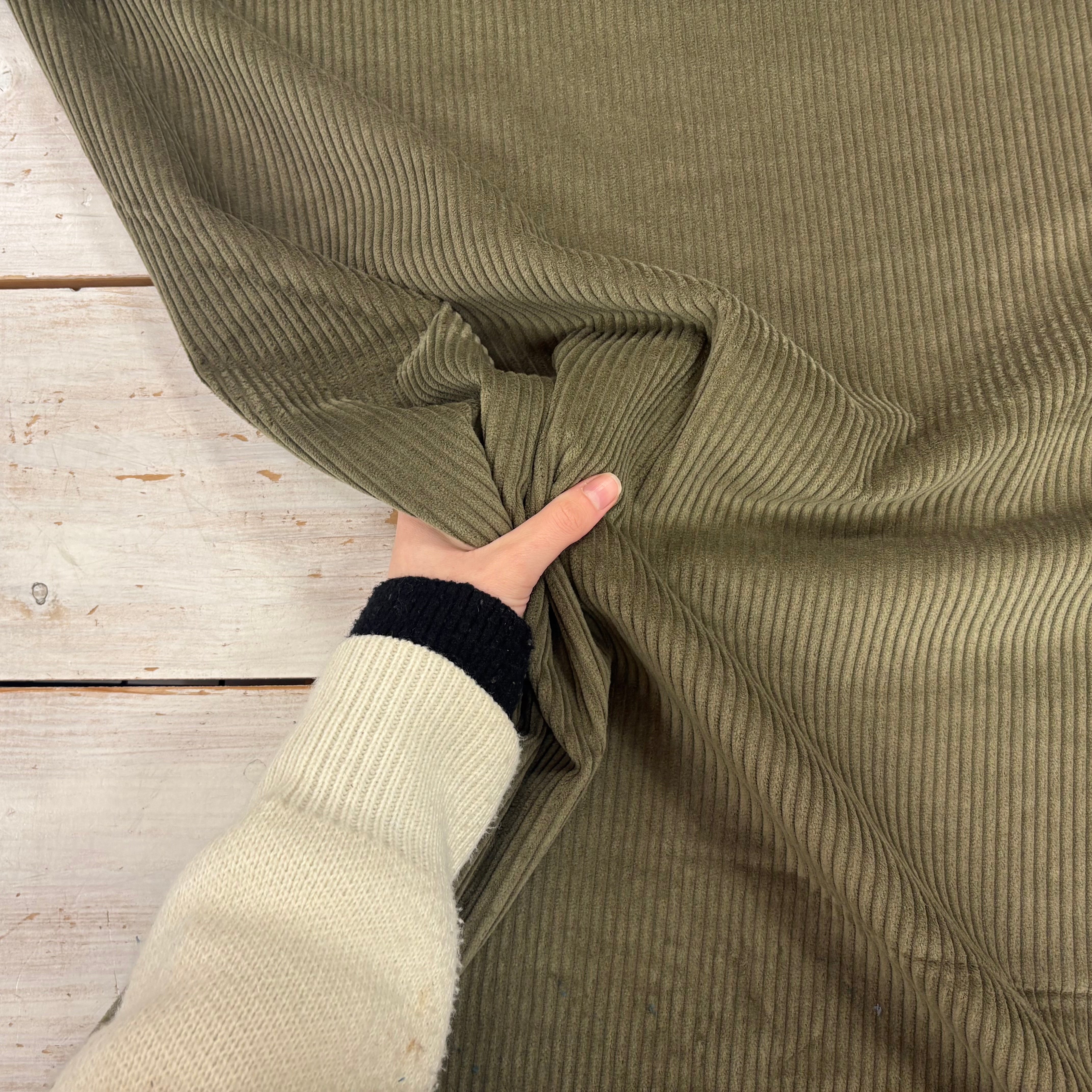 C845 4.5 Wale Corduroy Moss Fabric With Hand For Scale