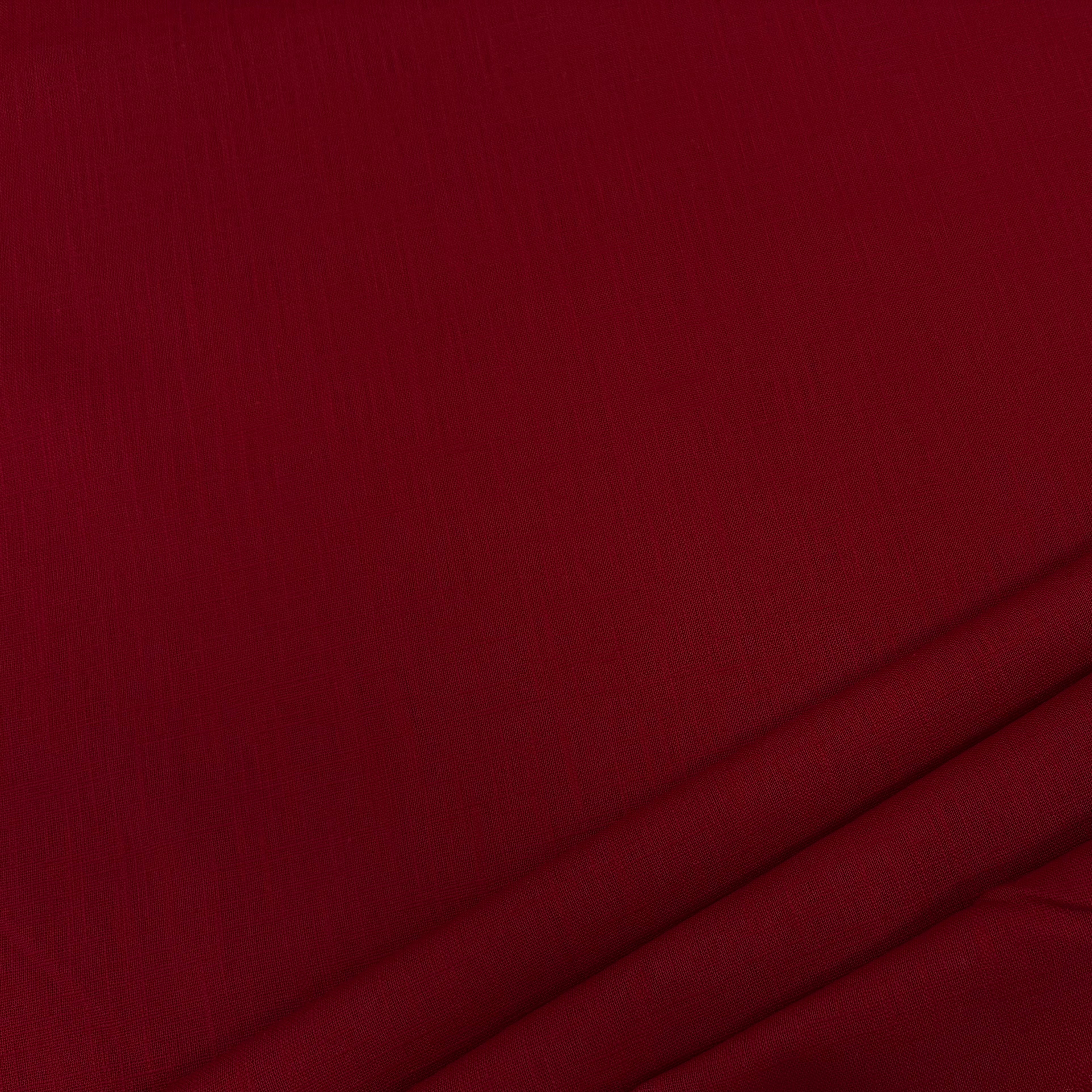 Close-up of deep red ramie linen dress fabric, highlighting its natural fibers, subtle weave pattern, and soft, slightly textured finish.