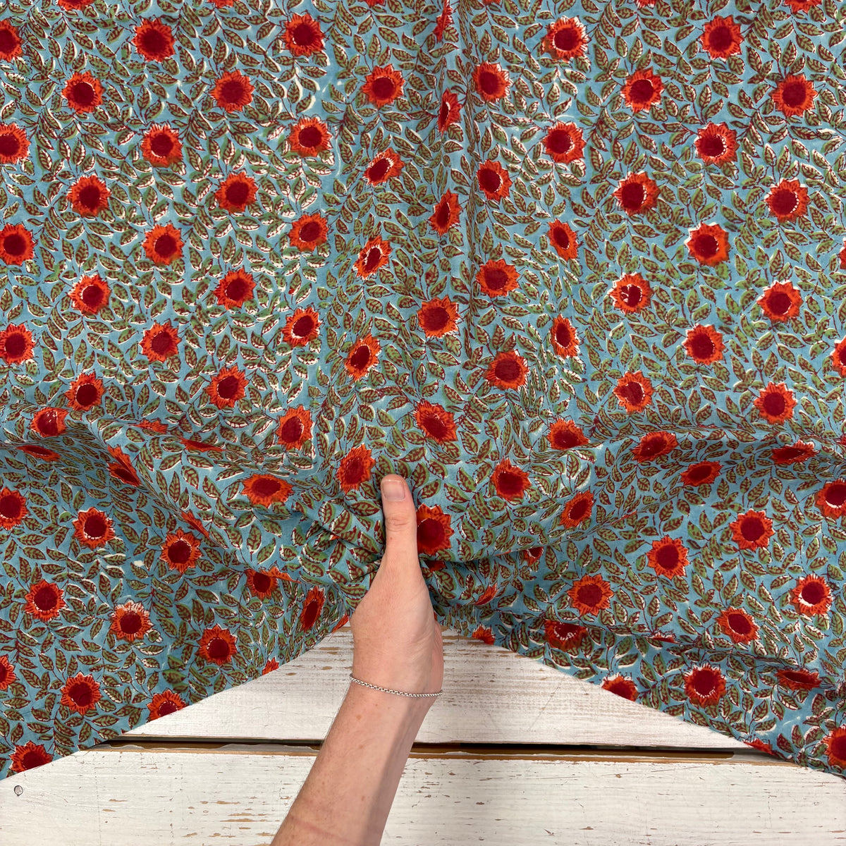 Sunflower Floral Block Print Cotton Fabric, with hand for scale, lightweight soft cotton with a traditional handcrafted Indian floral pattern