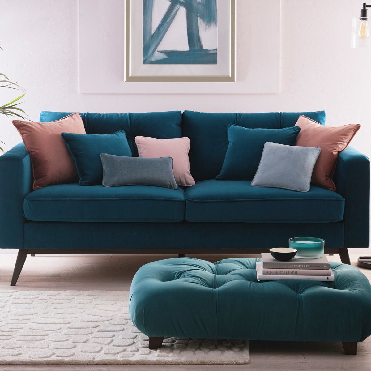Teal sofa with colorful cushions in a living room setting