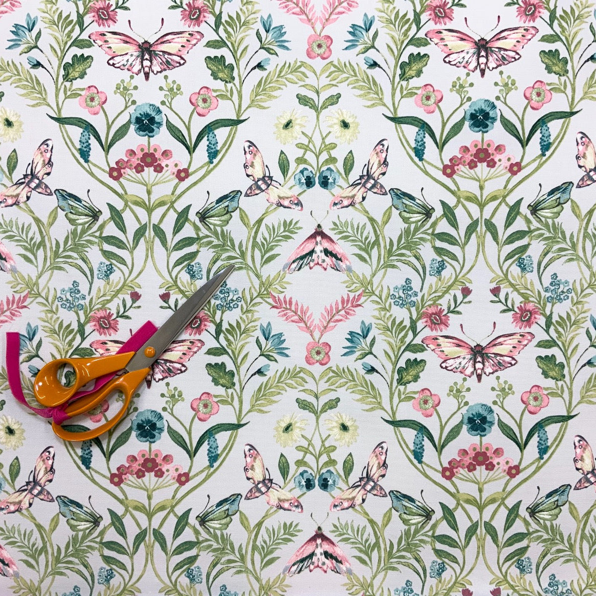 Clarke & Clarke Pieris Smoke floral cotton curtain fabric with butterflies. With scissors for scale.