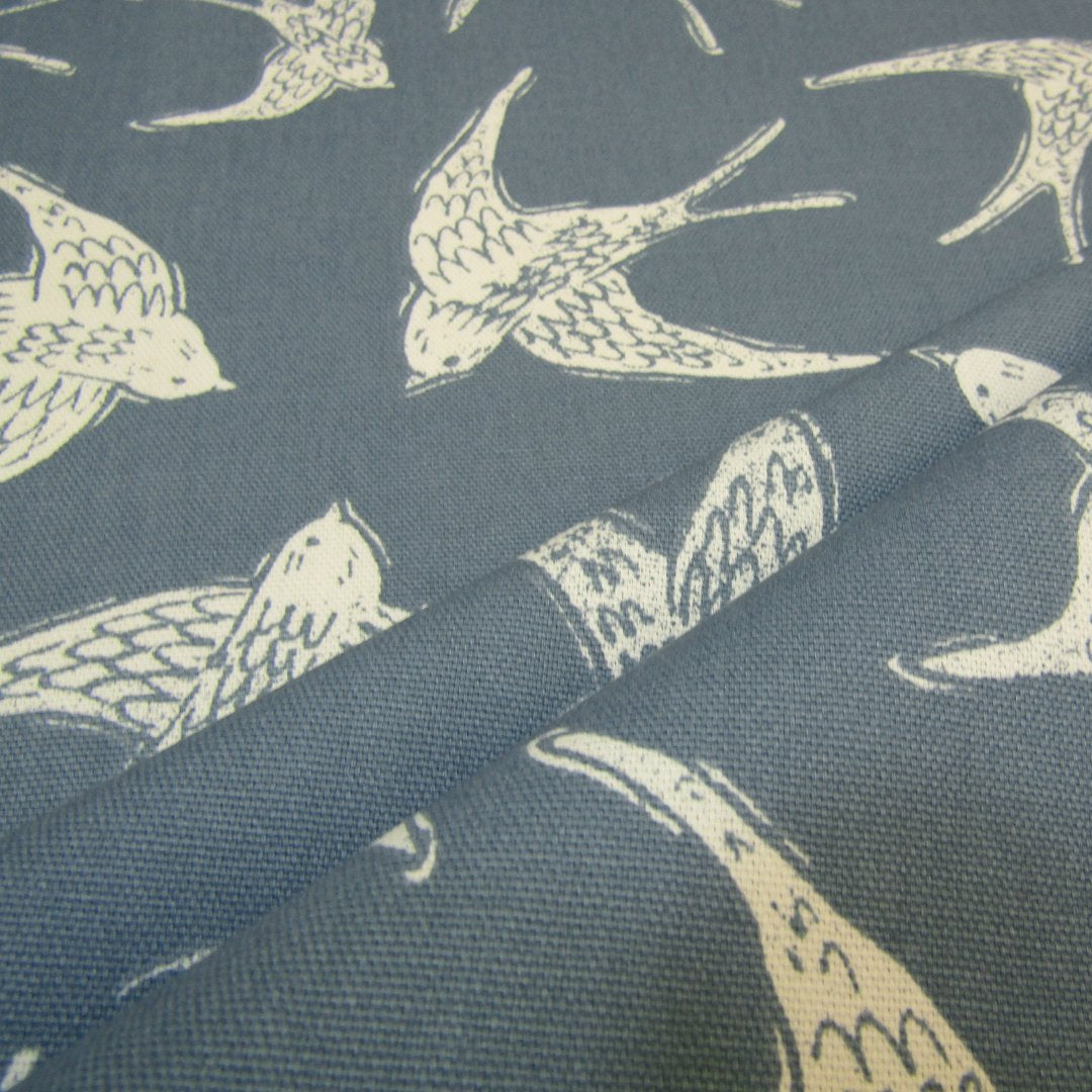 Cotton curtain fabric with coastal bird print on navy blue background.