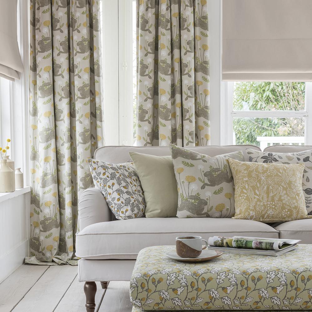 Living room with a gray sofa, floral-patterned cushions, and matching curtains.