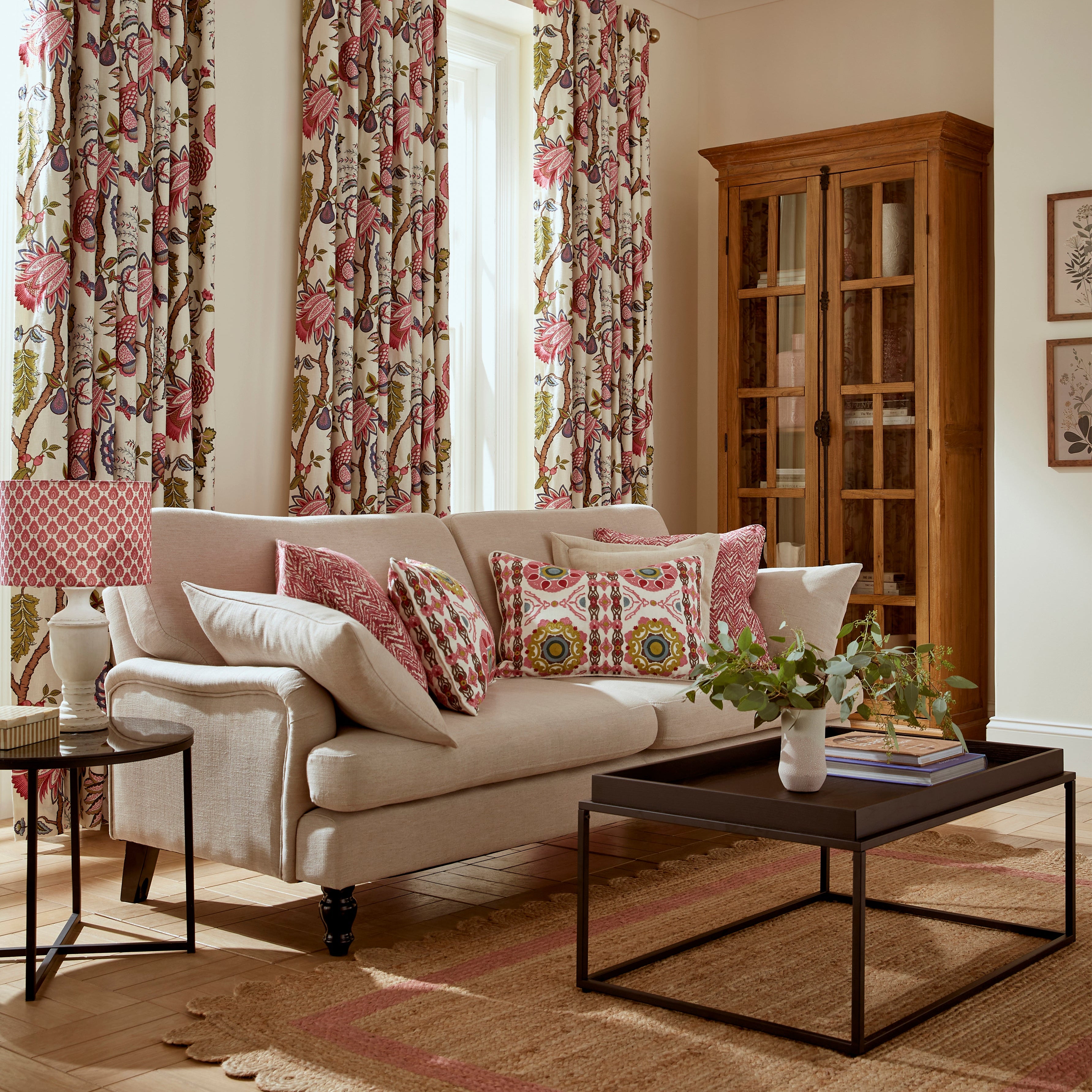 Living room with floral curtains, beige sofa, and decorative pillows.