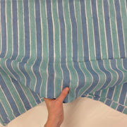 Blue Ocean Stripe Indian Print Cotton Fabric, with hand for scale, lightweight soft cotton with a traditional handcrafted Indian tartan check pattern.