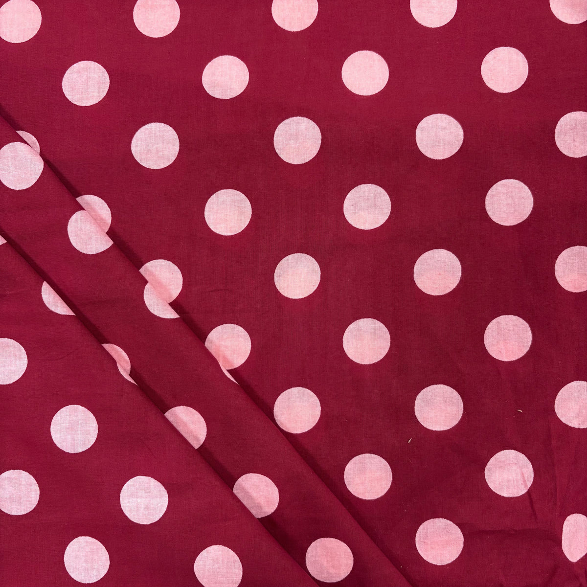 Burgundy Spotty Indian Print Cotton Fabric, folded. Lightweight 100gsm printed cotton for dressmaking, handmade gifts, crafts and soft furnishings, handcrafted using traditional Indian printing techniques.