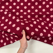 Burgundy Spotty Indian Print Cotton Fabric, with hand for scale. Lightweight 100gsm printed cotton for dressmaking, handmade gifts, crafts and soft furnishings, handcrafted using traditional Indian printing techniques.