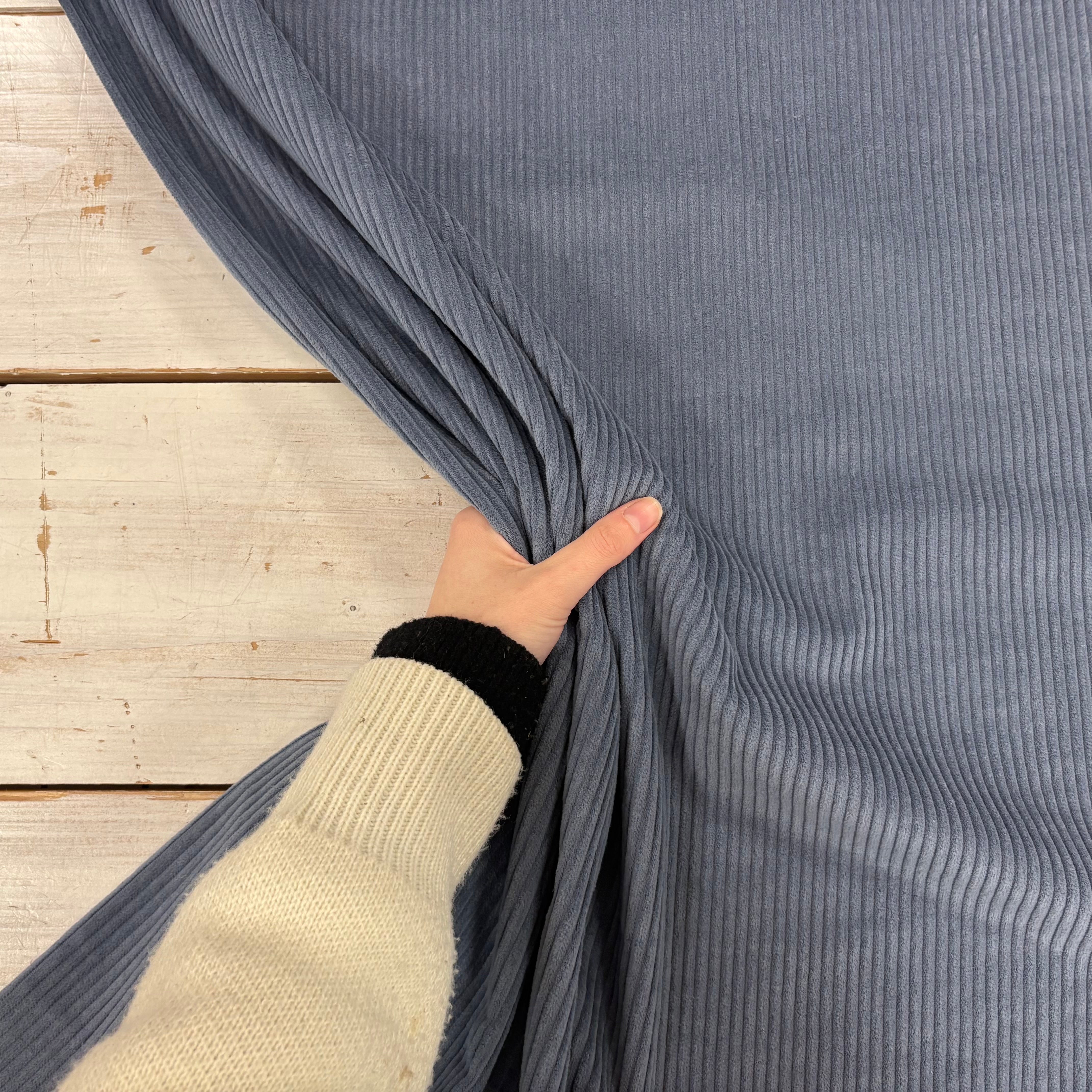 C844 4.5 Wale Corduroy Denim Fabric With Hand For Scale