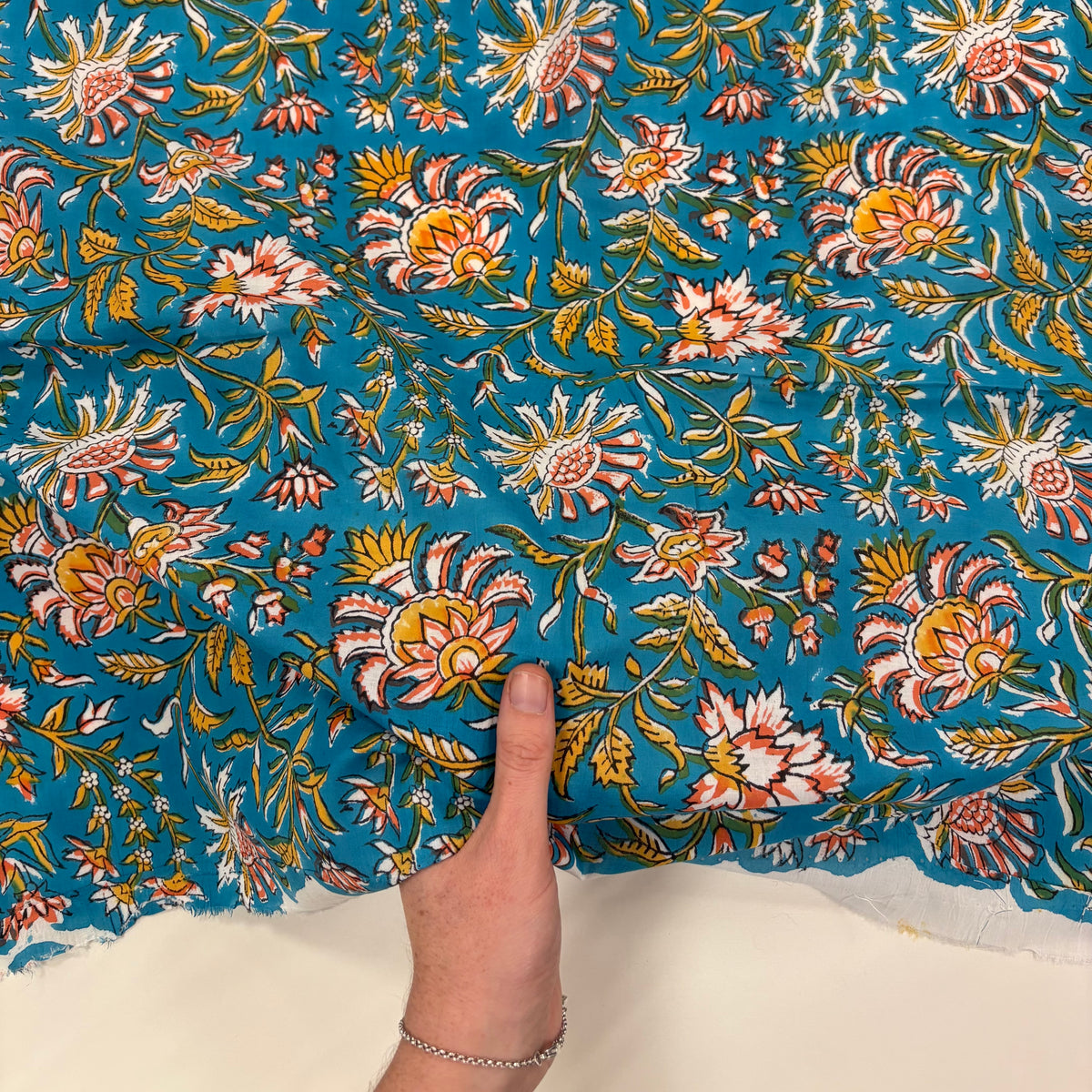 Celebration Floral Block Print Turquoise light weight cotton fabric Tex Ex 3045 with hand for scale