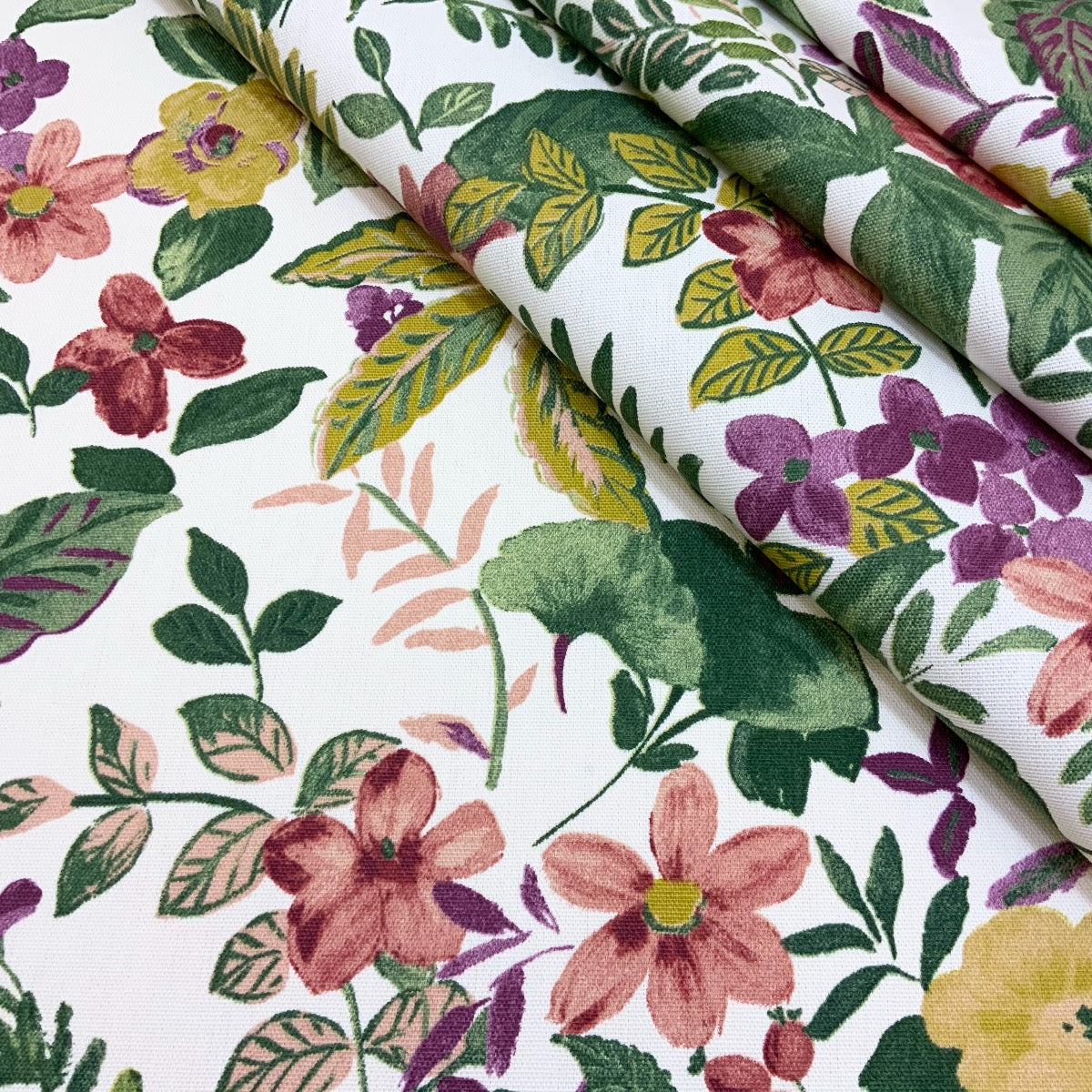 Clarke & Clarke floral cotton curtain fabric with leaves and birds with folds.