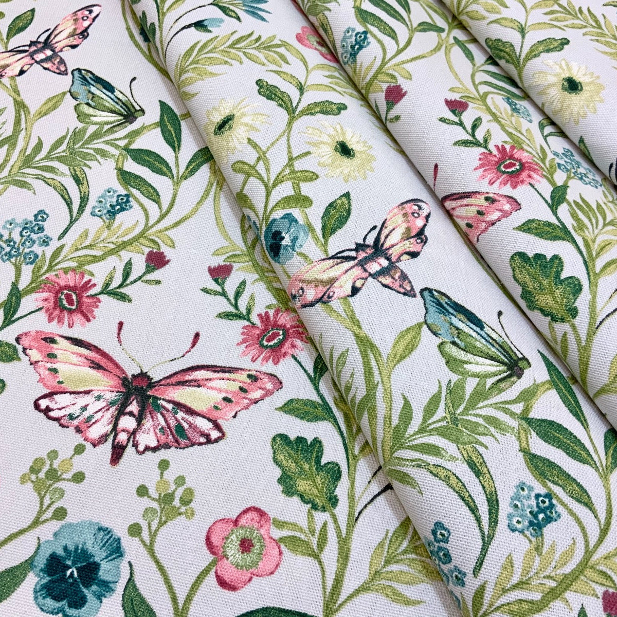 Clarke & Clarke Pieris Smoke floral cotton curtain fabric with butterflies. Folded.