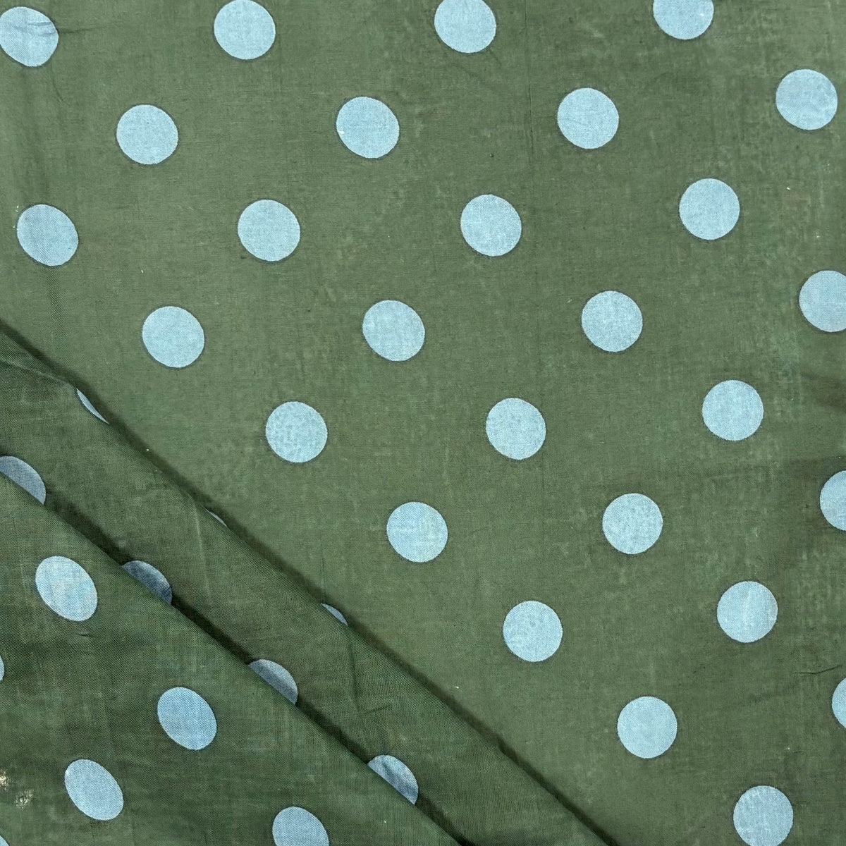 Forest Green Spotty Indian Print Cotton Fabric folded, lightweight 100gsm printed cotton for dressmaking, handmade gifts, crafts and soft furnishings, handcrafted using traditional Indian printing techniques.