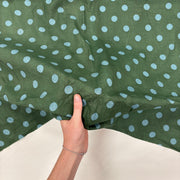 Forest Green Spotty Indian Print Cotton Fabric with hand for scale, lightweight 100gsm printed cotton for dressmaking, handmade gifts, crafts and soft furnishings, handcrafted using traditional Indian printing techniques.