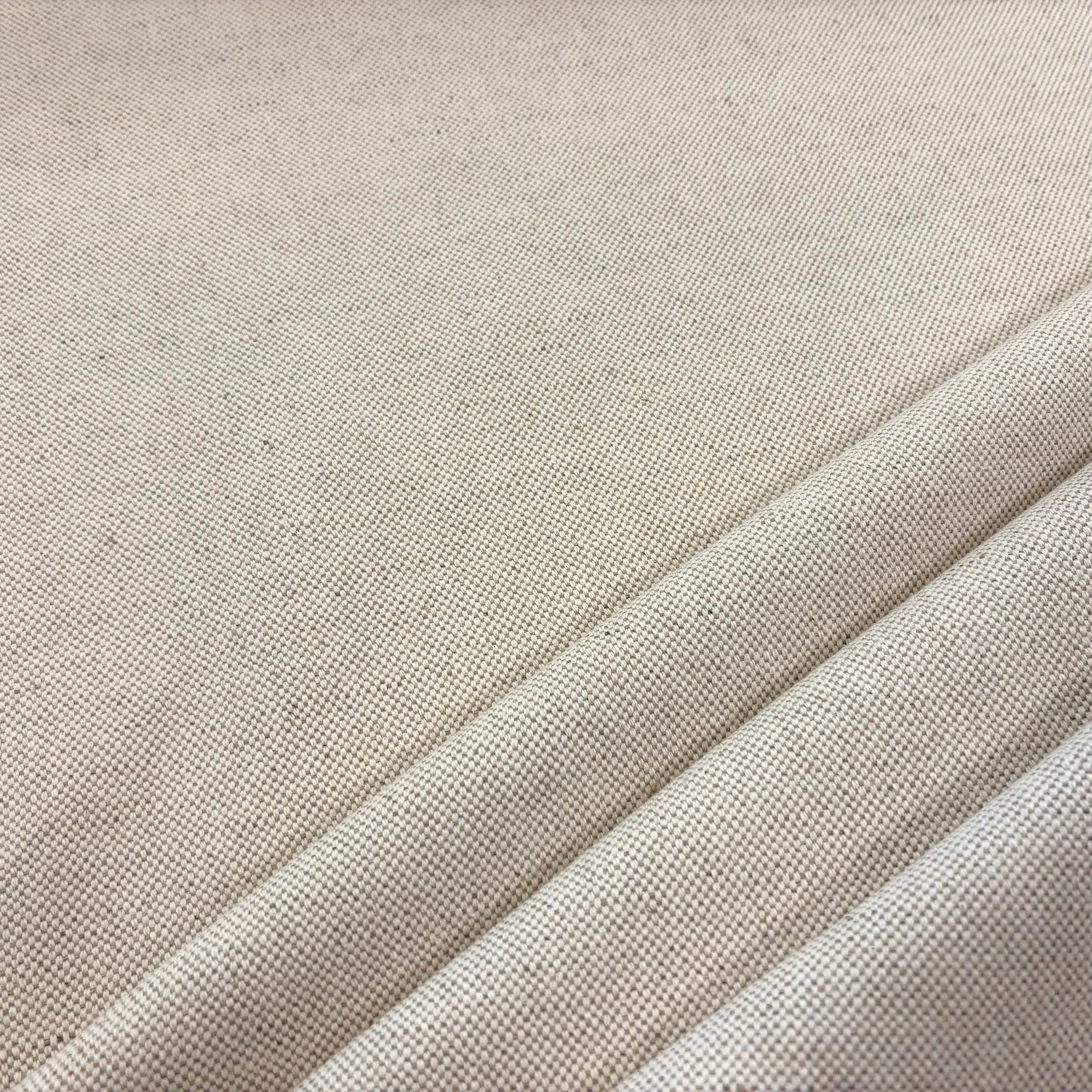 A close-up of a linen curtain fabric woven fabric with a fine textured weave, showing soft diagonal folds.