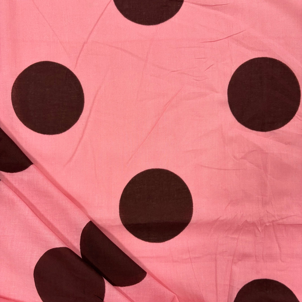 Pink Giant Spot Indian Print Cotton Fabric folded, lightweight 100gsm printed cotton for dressmaking, handmade gifts, crafts and soft furnishings, handcrafted using traditional Indian printing techniques.