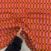 Pink Humbug Check Indian Block Print Cotton Fabric with hand for scale, lightweight 100gsm printed cotton for dressmaking, handmade gifts, crafts and soft furnishings, handcrafted using traditional Indian printing techniques.