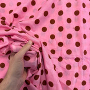 Pink Spotty Indian Print Cotton Fabric with hand for scale, lightweight 100gsm printed cotton for dressmaking, handmade gifts, crafts and soft furnishings, handcrafted using traditional Indian printing techniques.