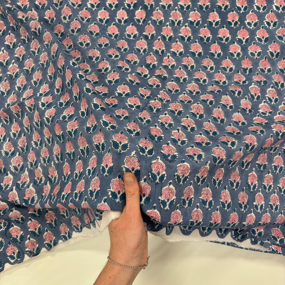 Rose Motif Floral block Print Cotton Fabric, with hand for scale, lightweight, soft cotton fabric featuring a traditional handcrafted Indian block print floral pattern, perfect for dressmaking, quilting, crafts, handmade gifts and light home décor projects.