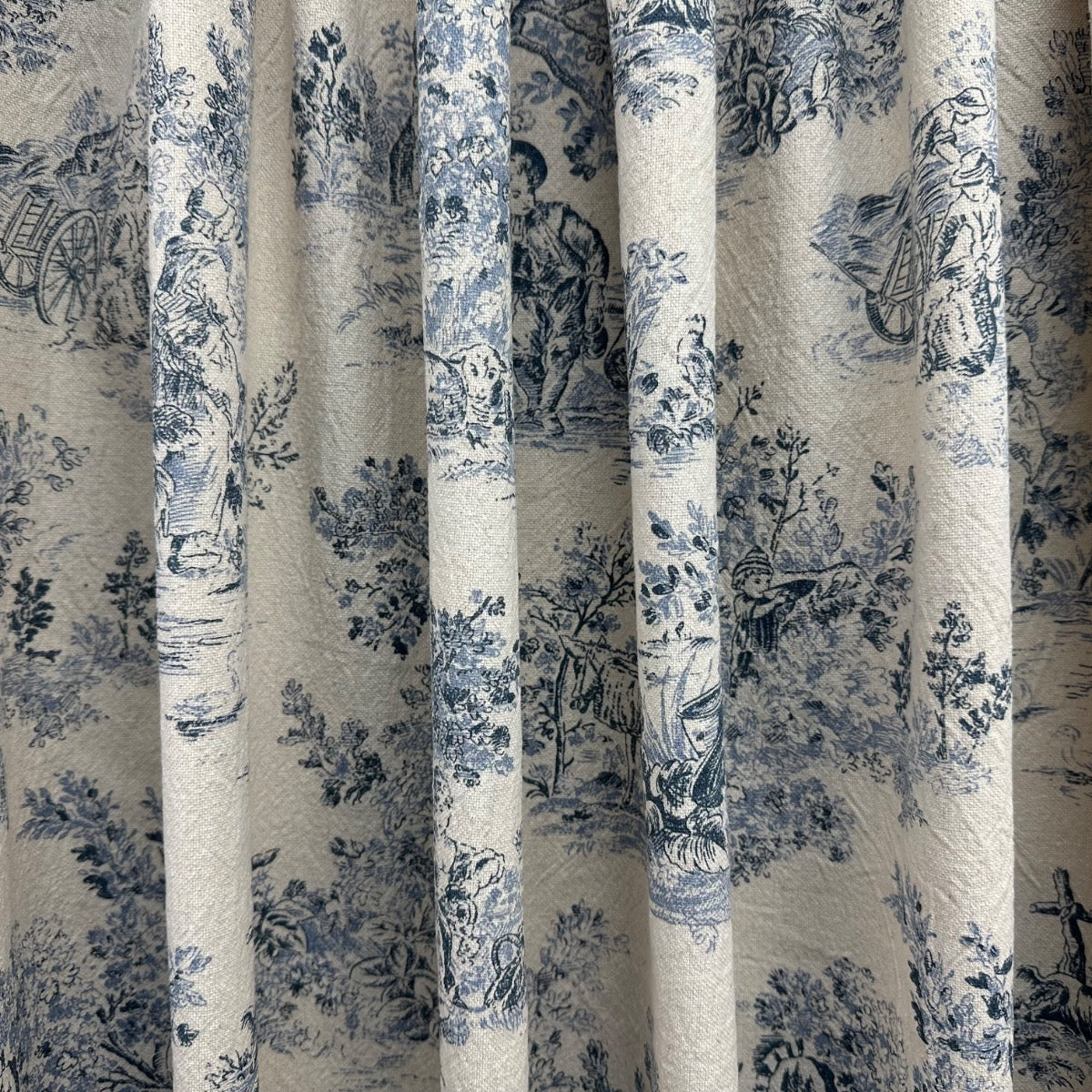 Rustic Toile Navy H412 Close-up of a curtain with blue floral pattern on beige background