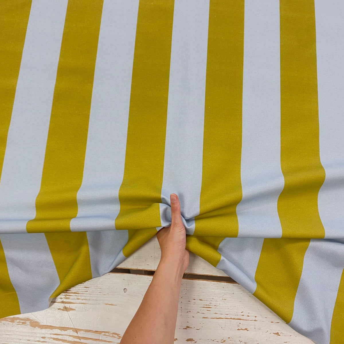 bold green and blue stripe cotton fabric with hand for scale