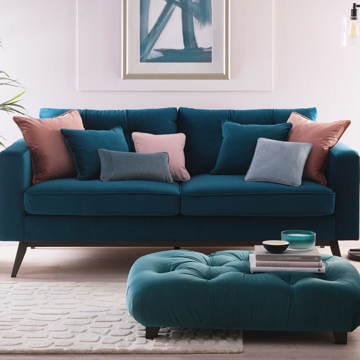 Teal sofa with colorful cushions in a living room setting