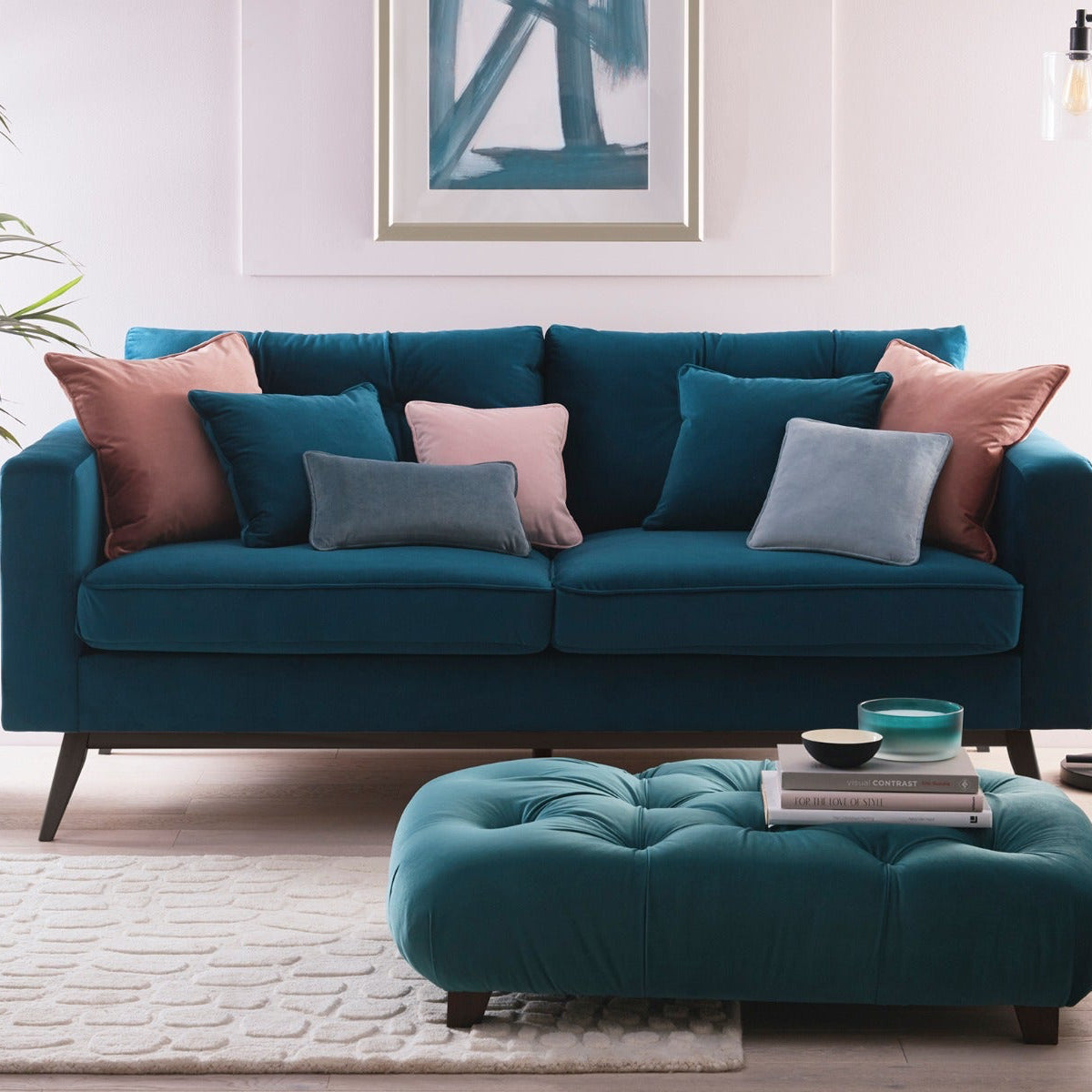 Teal sofa with colorful cushions in a living room setting