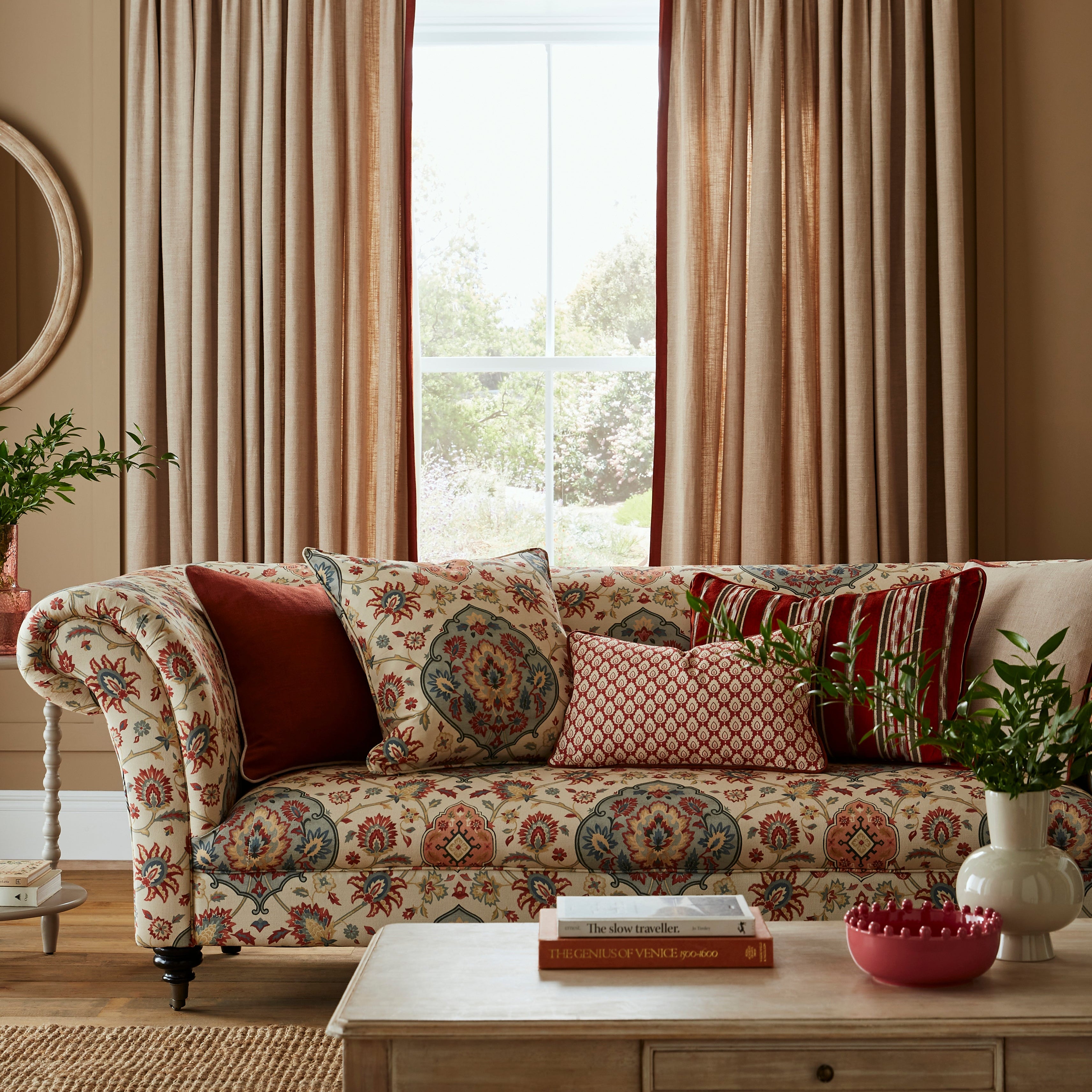 Living room with patterned sofa, decorative pillows, and curtains.
